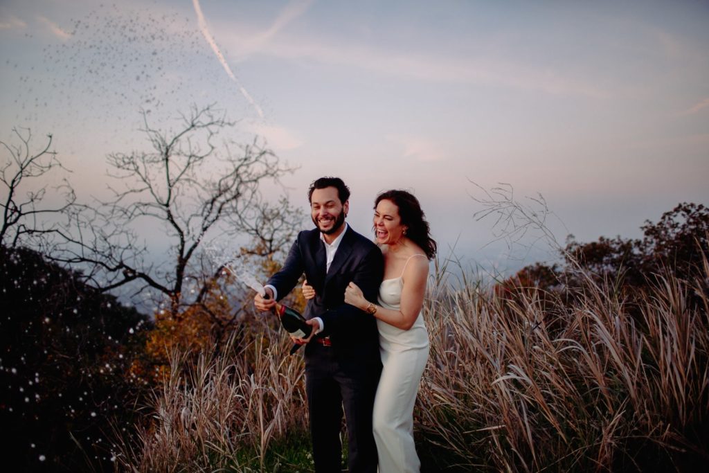 Couple Popping Champagne at their Adventure Elopement in Malibu California