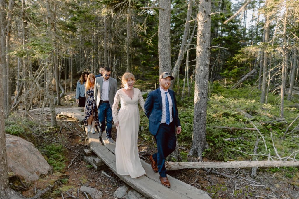 Bride and Groom walking with Friends through the Woods in Acadia