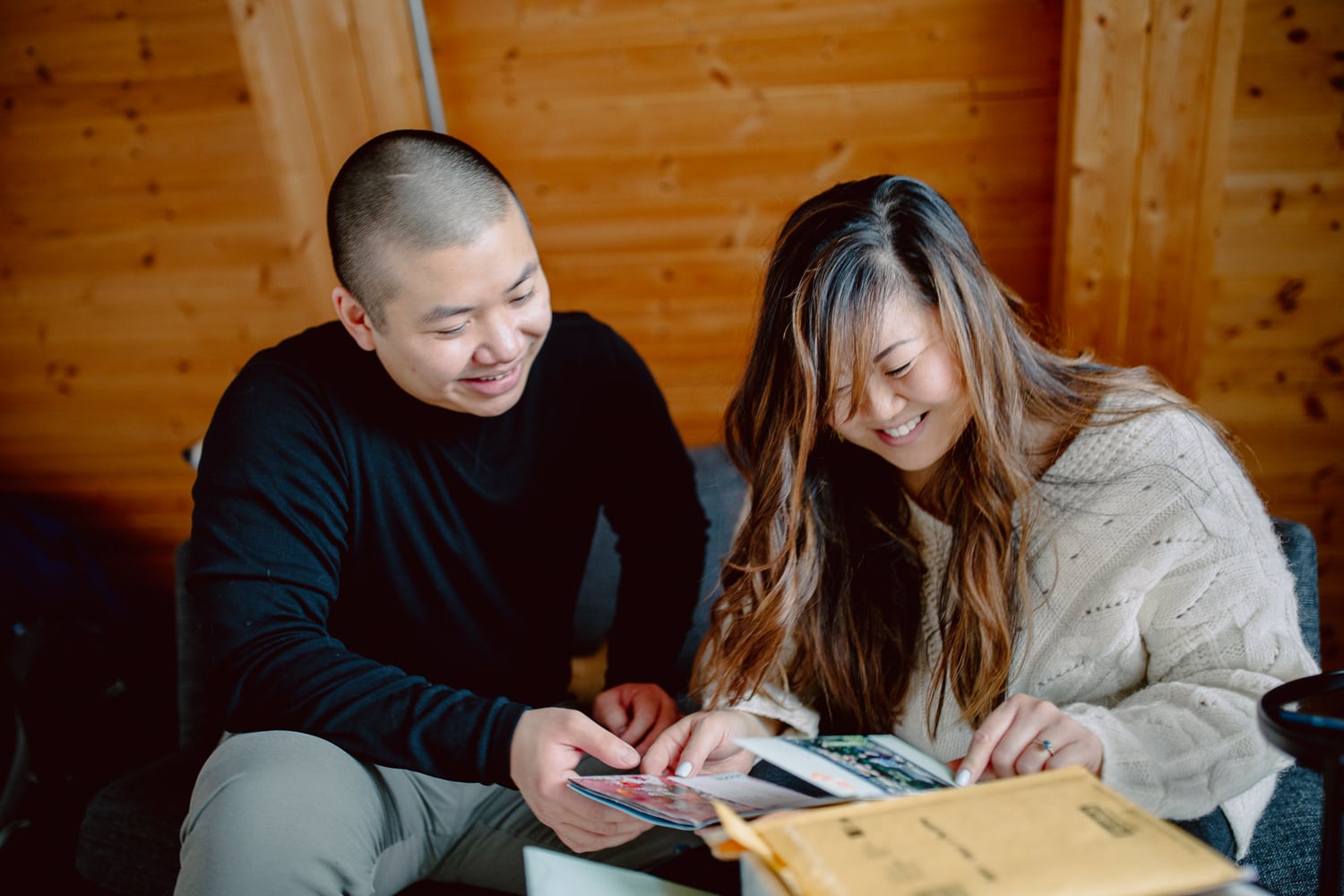 Couple Sitting on a Couch in A Cozy Cabin Reading Letters