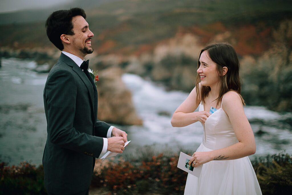Couple laughing as reading vows on their wedding day in Big Sur