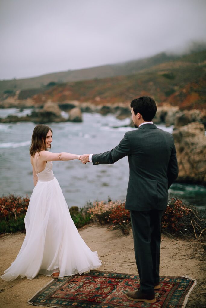 Couple dancing on wedding day on cliffs of big sur