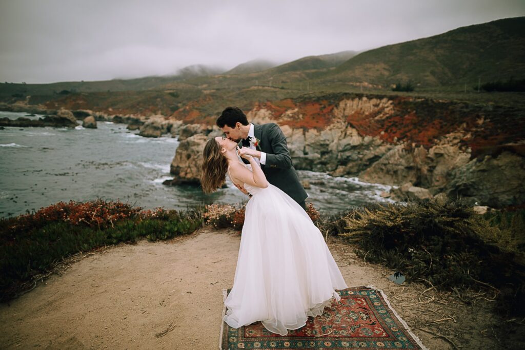 Bride and groom dancing on the cliffs of Big Sur