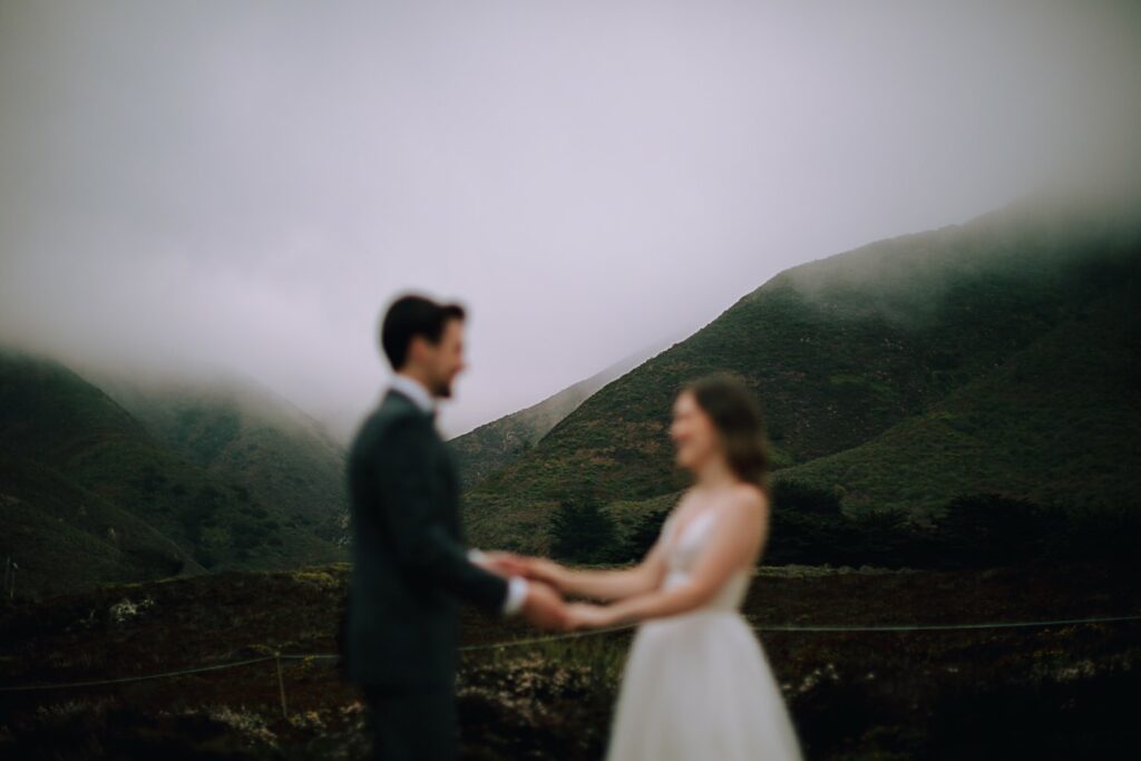 Couple holding hands on their foggy wedding day in Big Sur california