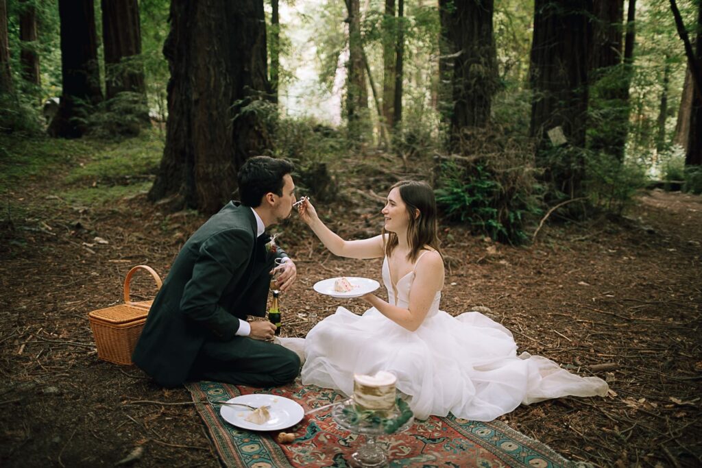 Couple feeding each other wedding cake in the Big Sur forest