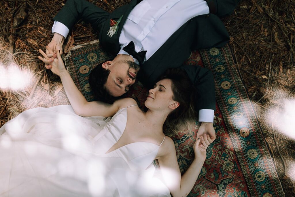 Couple lying down in the redwood forest at glen oaks on their wedding day